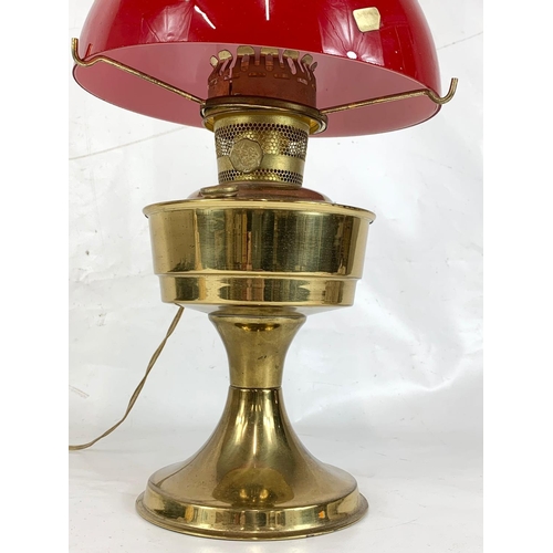 109 - Brass oil lamp with red glass shade, 59cm