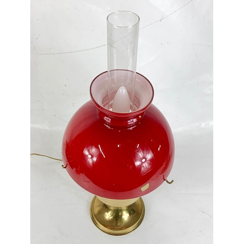 109 - Brass oil lamp with red glass shade, 59cm