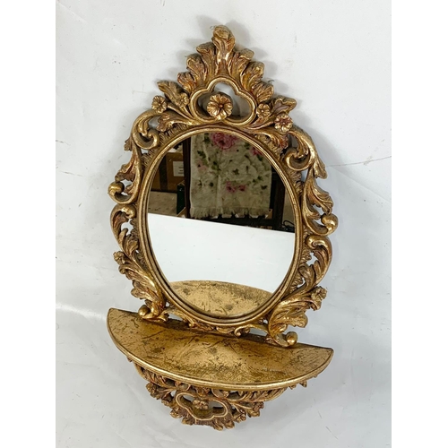 153 - A gilt framed mirror with shelf, 61cm x 37cm