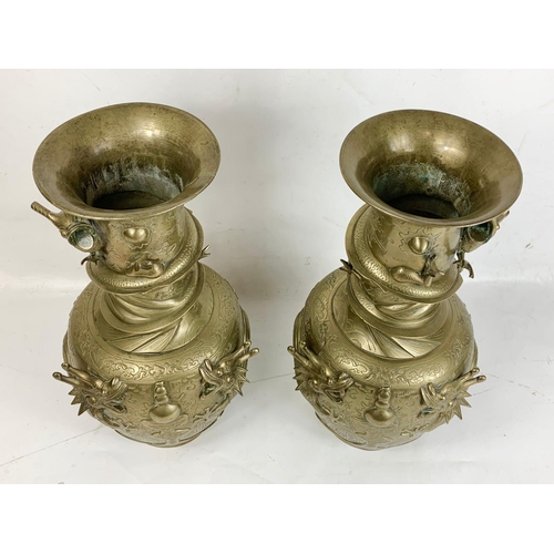 254 - A pair of large early 20th century brass Oriental vases with dragon decoration.  42cm