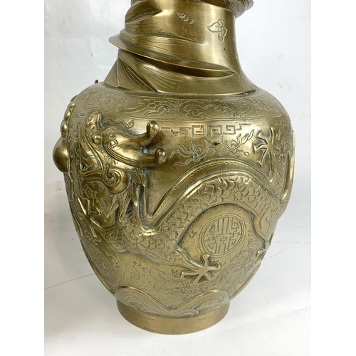 254 - A pair of large early 20th century brass Oriental vases with dragon decoration.  42cm