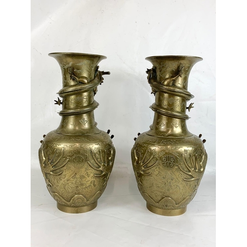 254 - A pair of large early 20th century brass Oriental vases with dragon decoration.  42cm