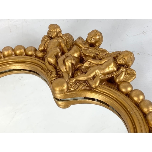 267 - A gilt framed heart shaped mirror with cherubs