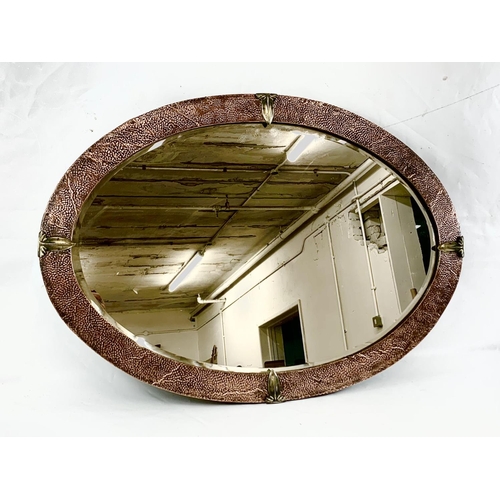 28 - An Arts & Crafts copper framed bevelled mirror, 86cm x 60cm