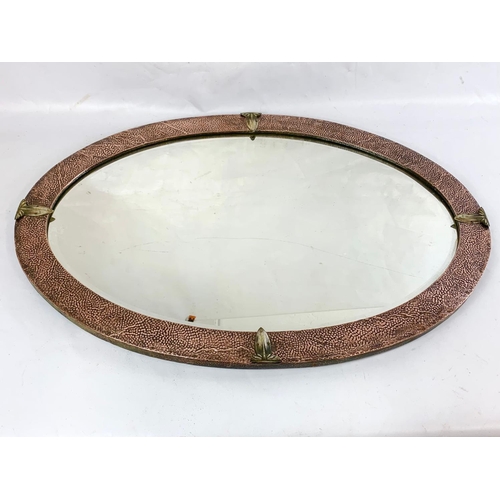 28 - An Arts & Crafts copper framed bevelled mirror, 86cm x 60cm