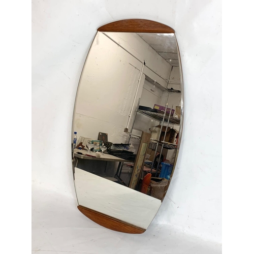 322 - A mid century teak framed mirror.  66x38cm