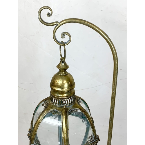 69 - An ornate brass candle stand, 160cm