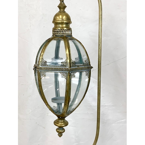 69 - An ornate brass candle stand, 160cm