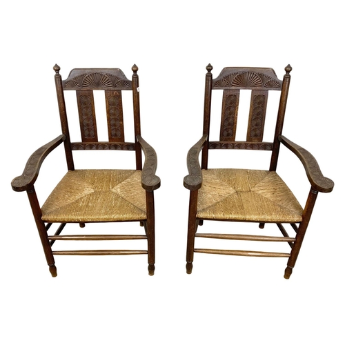 811 - A pair of Edwardian oak country armchairs with Aesthetic Movement influence