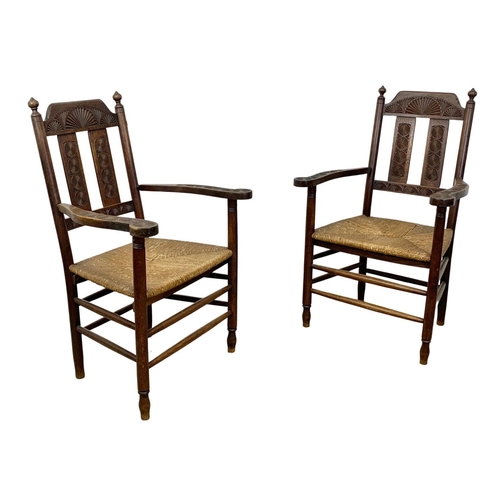 811 - A pair of Edwardian oak country armchairs with Aesthetic Movement influence