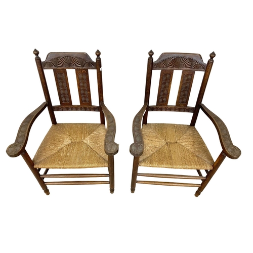 811 - A pair of Edwardian oak country armchairs with Aesthetic Movement influence