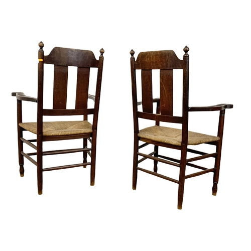 811 - A pair of Edwardian oak country armchairs with Aesthetic Movement influence