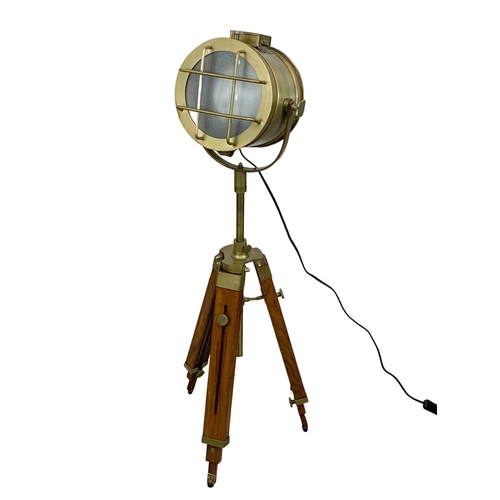 93 - A large brass search light style lamp on tripod stand, 136cm