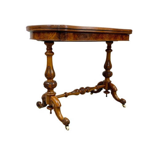 874a - A Victorian burr walnut turnover games table with stretcher. 96.5x51x75cm