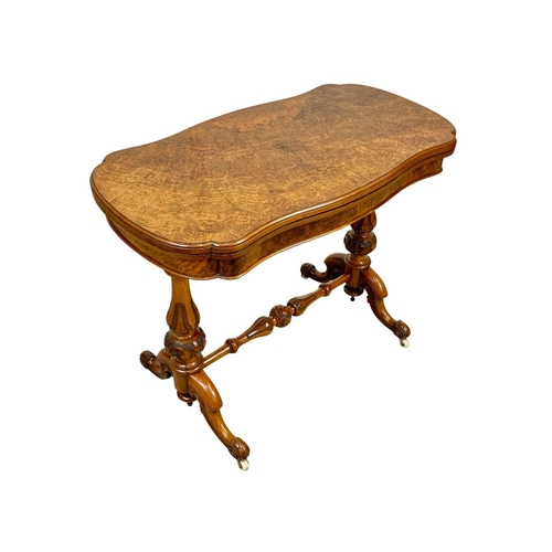 874a - A Victorian burr walnut turnover games table with stretcher. 96.5x51x75cm