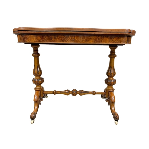 874a - A Victorian burr walnut turnover games table with stretcher. 96.5x51x75cm