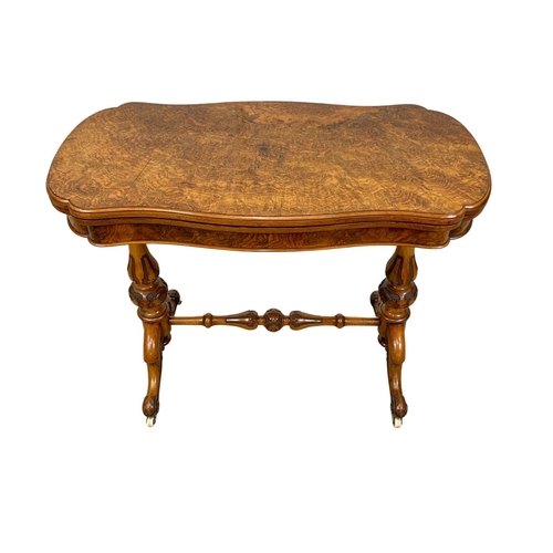 874a - A Victorian burr walnut turnover games table with stretcher. 96.5x51x75cm