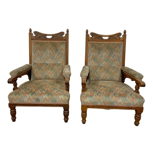 1062 - A pair of large Edwardian oak armchairs.