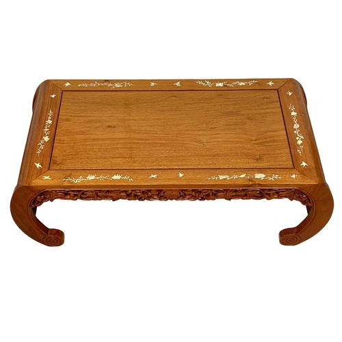 1066 - A Chinese teak coffee table inlaid with mother of pearl.  97x46x34cm