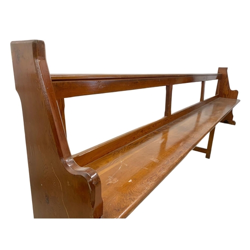 1102 - A large early 20th century pitch pine church pew/bench. 334cm.