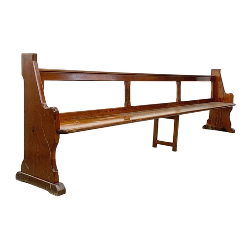 1102 - A large early 20th century pitch pine church pew/bench. 334cm.