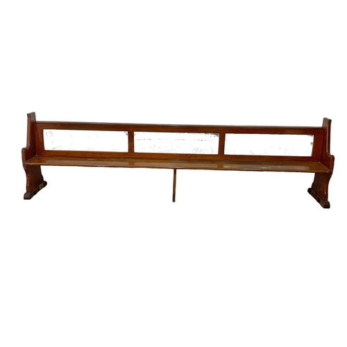 1102 - A large early 20th century pitch pine church pew/bench. 334cm.