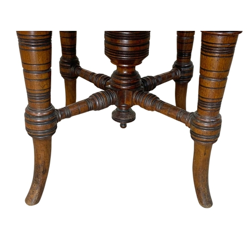 1003 - A Victorian walnut revolving piano stool.