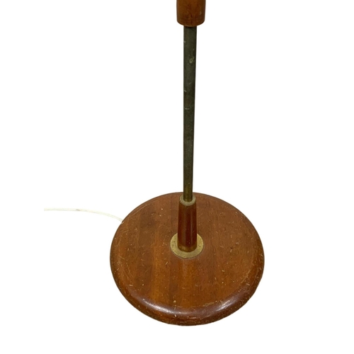 1007 - A teak and brass Mid Century standard lamp. 141cm.