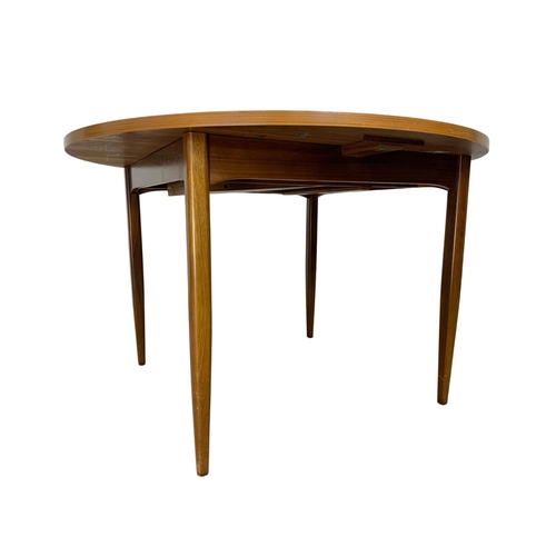 1092 - A Mid Century extending dining table. Extended 156 x 118 x 74cm.