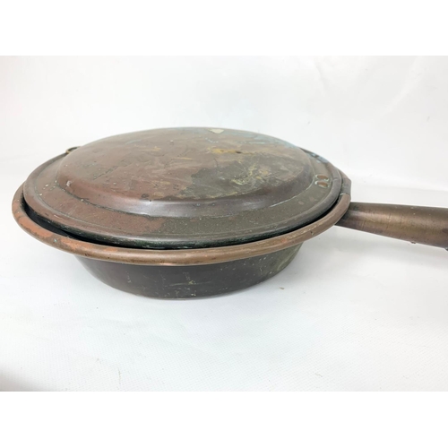 119 - A Victorian copper bed pan and a vintage brass bed pan. Largest 106cm