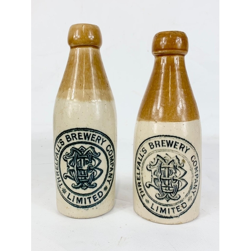 12 - 2 Threlfall’s Brewery Company Limited glazed stone bottles. 20cm.