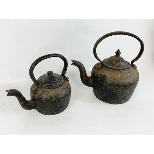 183 - 2 Victorian cast iron kettles. Largest 35 x 33cm.