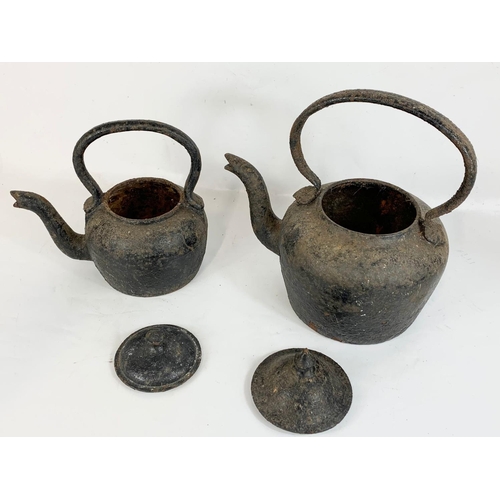 183 - 2 Victorian cast iron kettles. Largest 35 x 33cm.