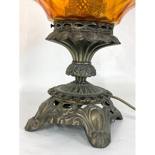 318 - A large ornate brass table lamp with amber glass shade. 51cm