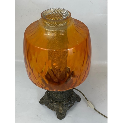 318 - A large ornate brass table lamp with amber glass shade. 51cm