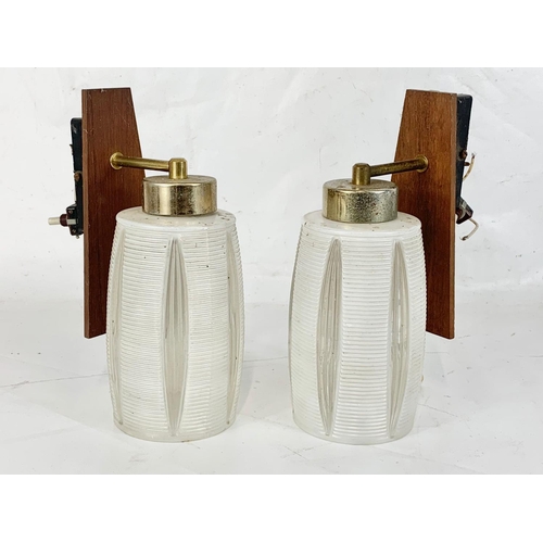 36 - A pair of mid century teak and brass wall lights with glass shades. 24cm.