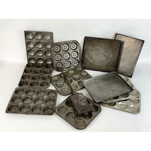 364 - A quantity of Edwardian baking trays and a cast iron waffle maker.