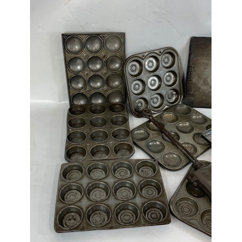 364 - A quantity of Edwardian baking trays and a cast iron waffle maker.