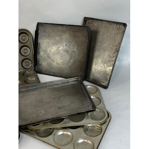 364 - A quantity of Edwardian baking trays and a cast iron waffle maker.