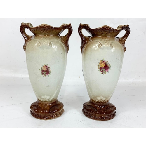 487 - A pair of Edwardian pottery vases. 25.5cm.