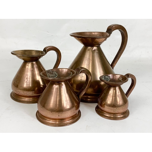 59 - A set of 4 early 20th century copper measuring jugs. Largest 18 x 16.5cm.