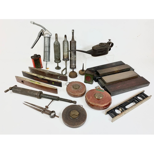 60 - A quantity of vintage tools. Including oil dispensers, an oil can, levels, tape measures, sharpening... 