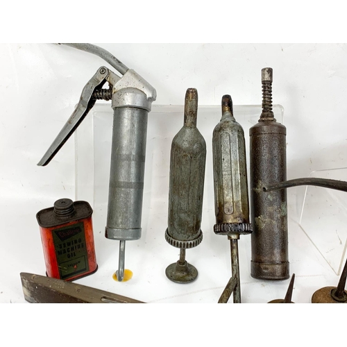 60 - A quantity of vintage tools. Including oil dispensers, an oil can, levels, tape measures, sharpening... 