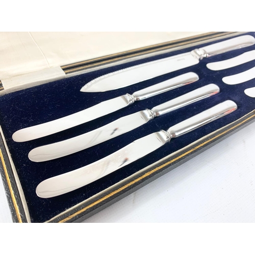 652 - A set of silver plate knives in case.