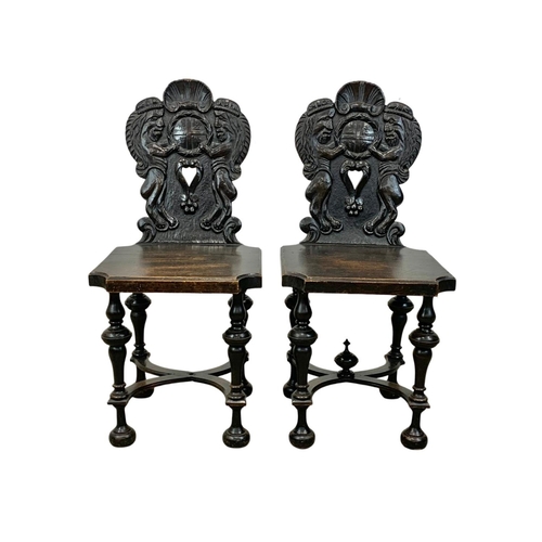 827 - A pair of 19th century continental carved oak hall chairs in the medieval style. Circa 1880.