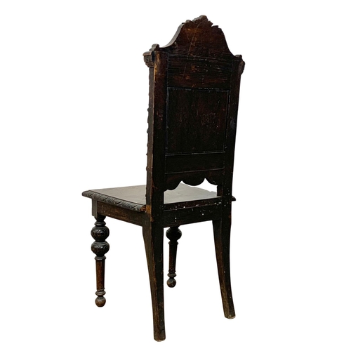 859 - A late Victorian carved oak hall chair. Circa 1880. Ground to back 108cm