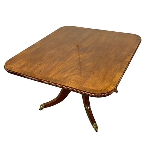 860 - A large George IV mahogany tilt top pedestal dining table, with rosewood cross banding, gadrooned ed... 