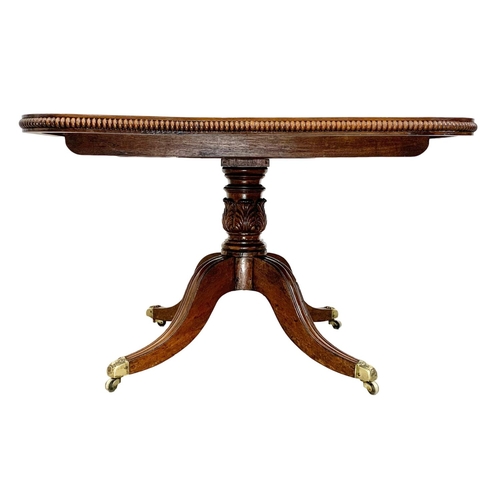 860 - A large George IV mahogany tilt top pedestal dining table, with rosewood cross banding, gadrooned ed... 