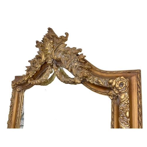 894 - A very large heavily gilt framed mirror. 100 x 214cm