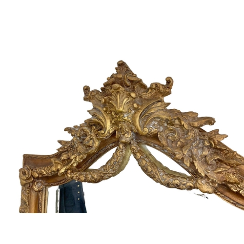 894 - A very large heavily gilt framed mirror. 100 x 214cm